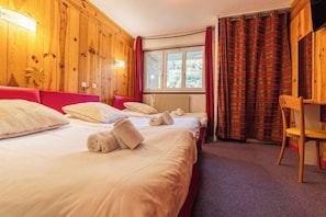 A hotel room with two beds, a wooden wall, a window, and a chair. - Hotel Club mmv Serre Chevalier L Alpazur (Monetier-les-Bains)