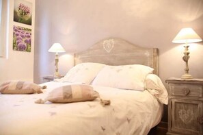 A bed with two pillows, a wooden headboard, and two bedside tables with lamps. - Villa Castel Chambres Dhotes (Rillieux-la-Pape)