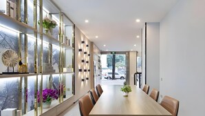 A modern conference room with a long table, chairs, and a glass partition with decorative items. - 7 Days Inn Sea World 2nd Branch (Shenzhen)
