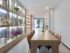 A modern conference room with a long table, chairs, and a glass partition with decorative items. - 7 Days Inn Sea World 2nd Branch (Shenzhen)
