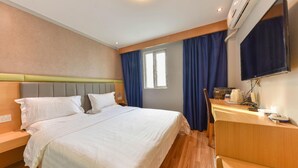 A hotel room with a bed, a desk, a chair, a television, and an air conditioning unit. - 7 Days Inn Sea World 2nd Branch (Shenzhen)