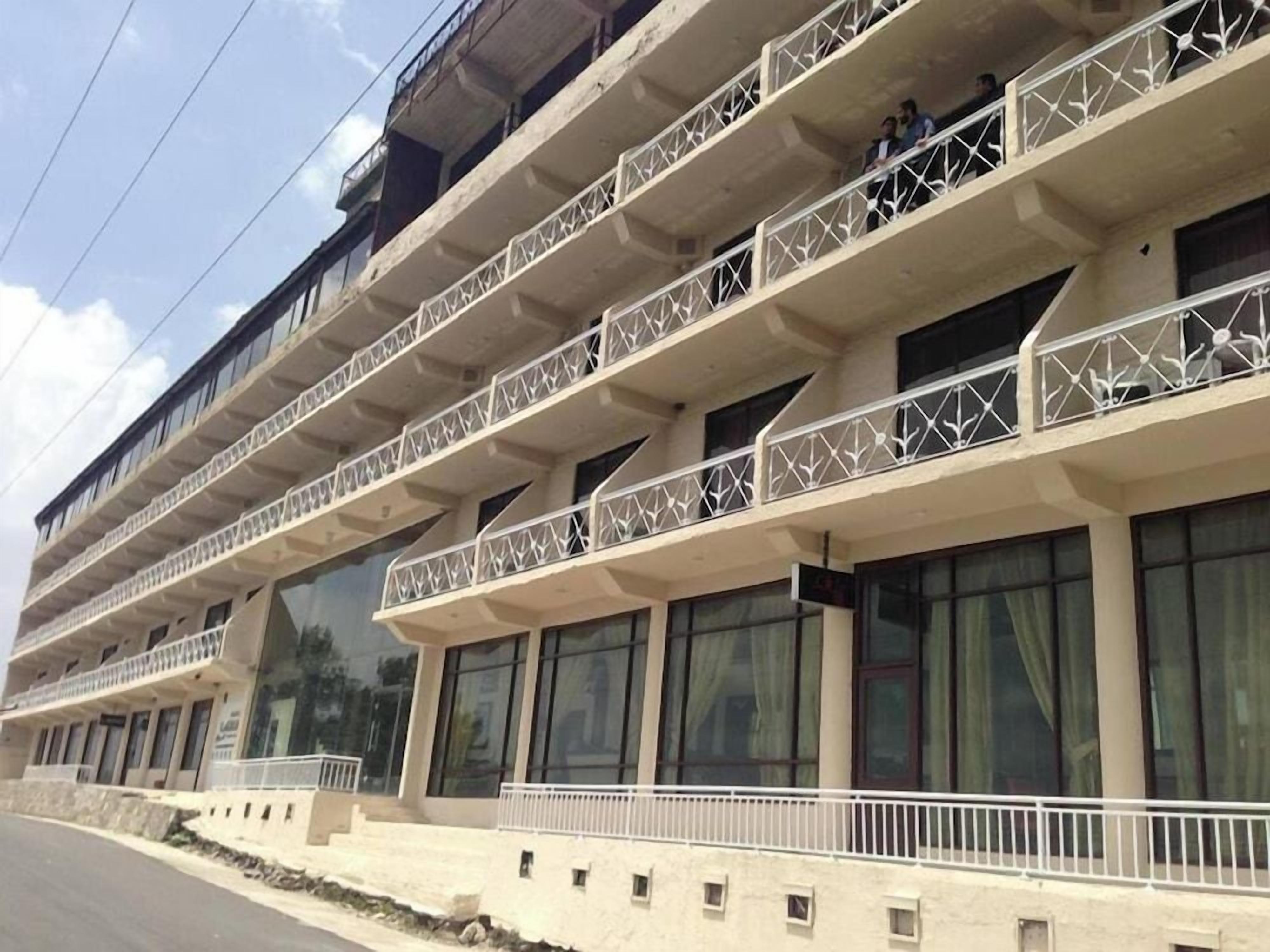 A multi-story building with balconies and large windows.