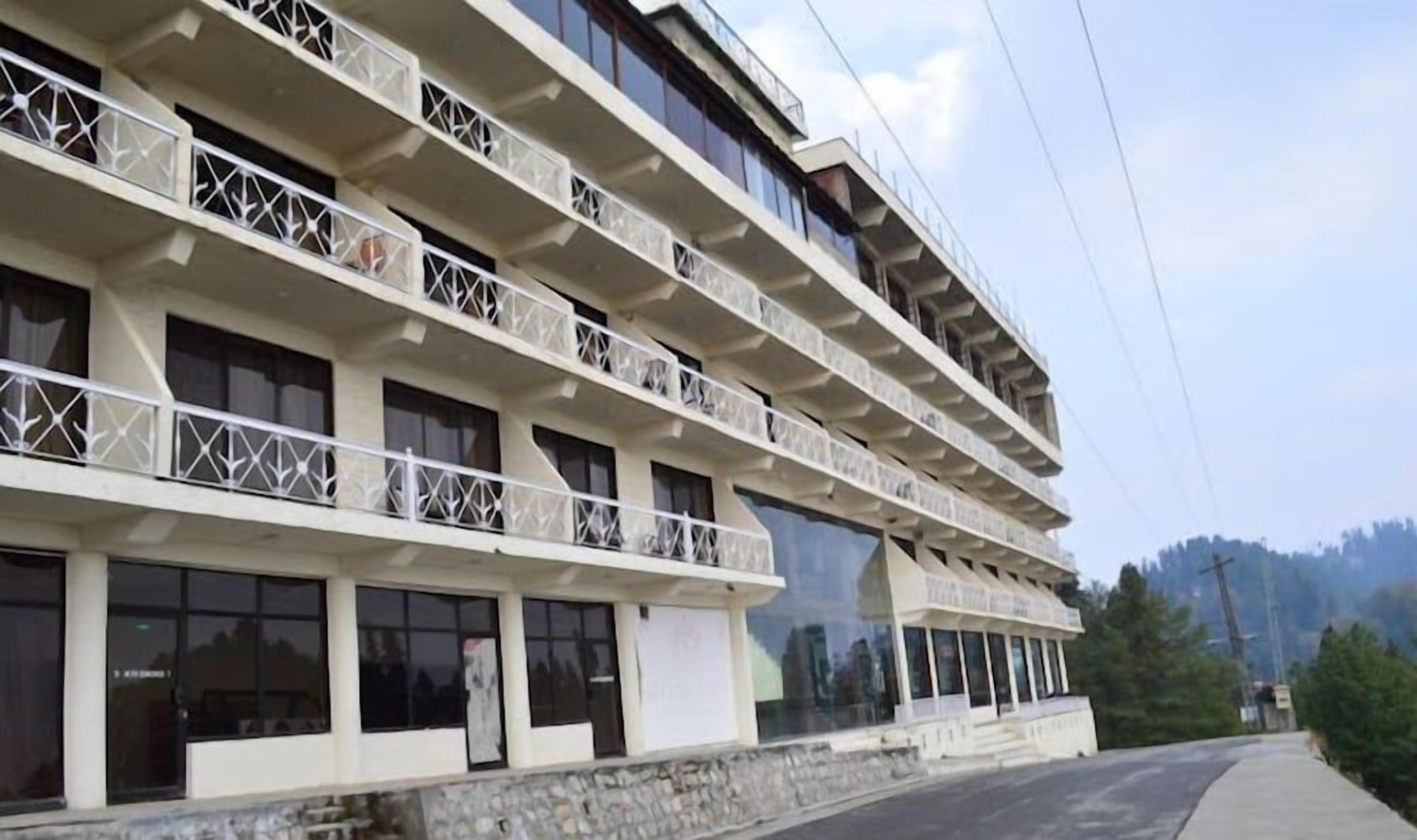 Un hôtel à plusieurs étages, doté de balcons et de grandes fenêtres.