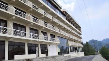 Un hotel de varios pisos con balcones y ventanas amplias.