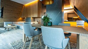 A modern interior with a dining area, sofas, and a staircase. - Monti Spa Wellness Hotel Igman (Hadzici)