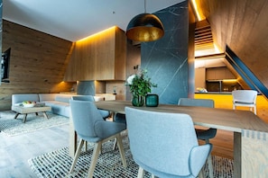 Ein modernes Interieur mit Essbereich, Sofas und einer Treppe.