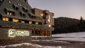 A modern building with a stone facade and a sign that reads 'mont.' - Monti Spa Wellness Hotel Igman (Hadzici)