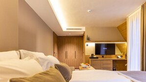 A hotel room with a bed, a desk, a television, and a kitchenette. - Monti Spa Wellness Hotel Igman (Hadzici)