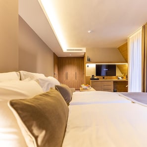 Ein Hotelzimmer mit Bett, Schreibtisch, Fernseher und einer Küchenzeile.
