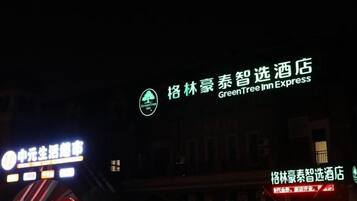 A building with illuminated signage, including a prominent hotel name and a logo.