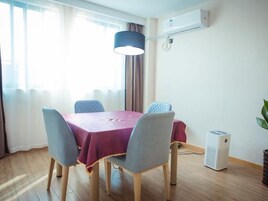 Un comedor con una mesa, sillas y un equipo de aire acondicionado.