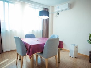 Een eethoek met een tafel, stoelen en een airconditioning.