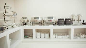 A clean, white room with shelves containing various kitchen appliances and utensils.