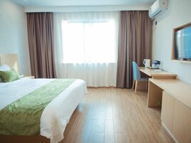 Una habitación de hotel con una cama, un escritorio, una silla y un televisor.