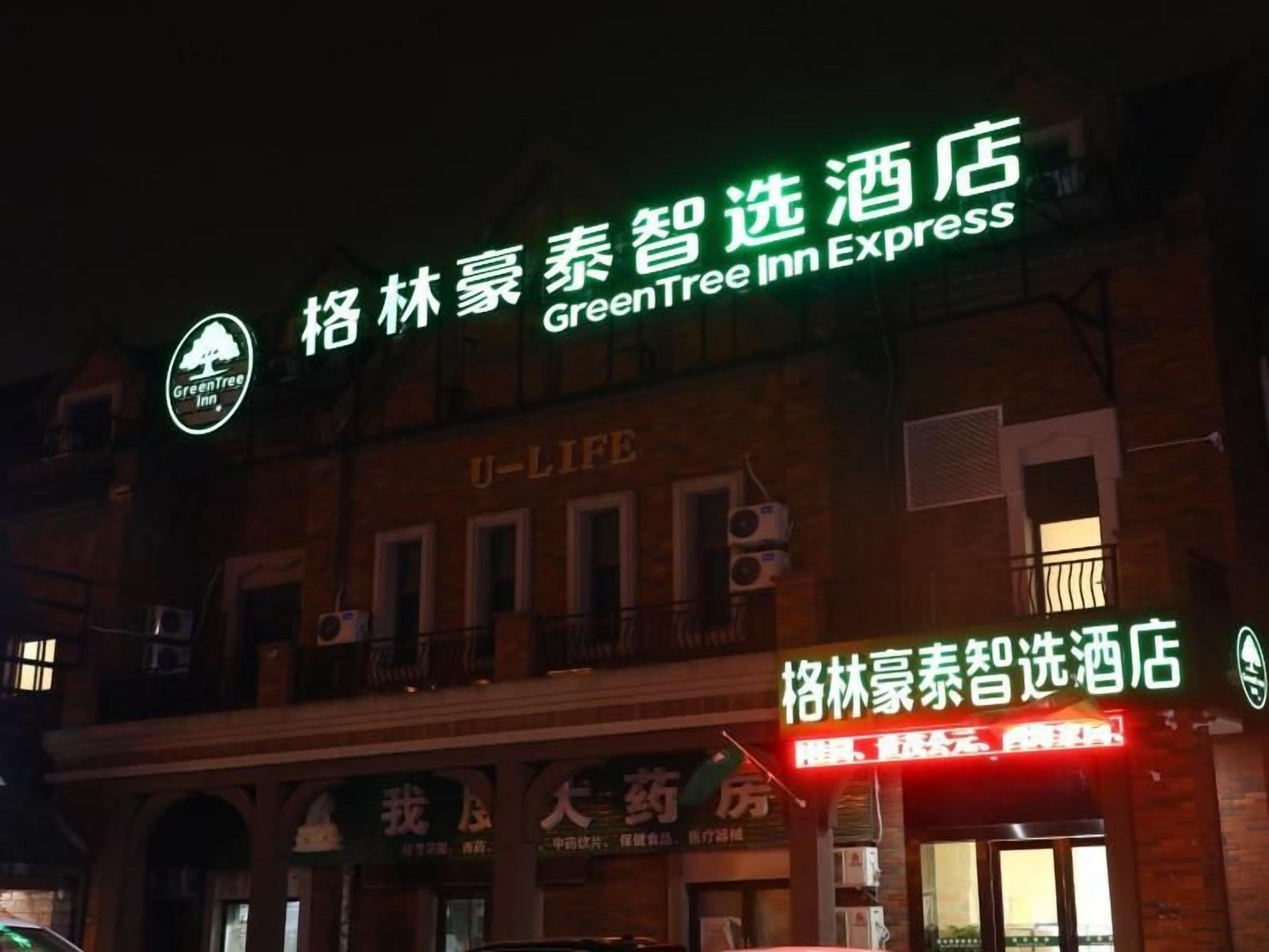 Un hotel con señalización para GreenTree Inn Express y un establecimiento U-Life.