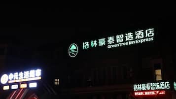 Um edifício com sinalização iluminada, incluindo o nome de um hotel em destaque e um logotipo.