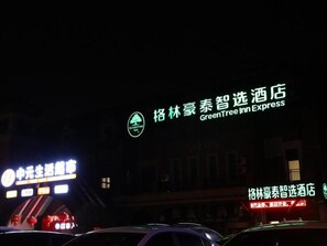 Un edificio con señalización iluminada, incluyendo el nombre destacado de un hotel y un logotipo.