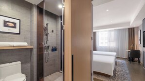 A modern hotel room with a shower, toilet, and a bed. - Atour Light (Zhuhai)