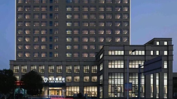 En hotelbygning med flere etager, en markant indgang og skiltning.