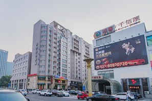 A multi-story building with commercial establishments on the ground floor, including a restaurant and a shop. - Home Inn (Tianjin)