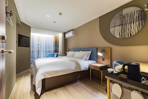 A hotel room with a bed, bedside table, lamp, and a wall-mounted TV. - Home Inn (Tianjin)