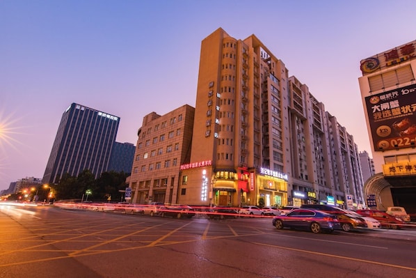 A multi-story hotel with a prominent entrance and signage. - Home Inn (Tianjin)