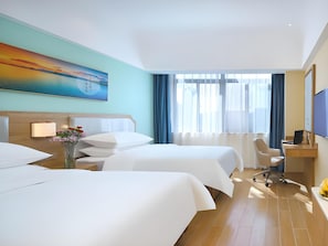 A hotel room with two beds, a desk, a chair, a TV, and a painting on the wall. - Vienna 3 Best Hotel (Lu'an)