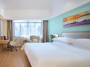 A hotel room with a large bed, two chairs, a desk, and a window with curtains. - Vienna 3 Best Hotel (Lu'an)