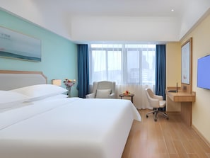 A hotel room with a bed, a desk, a chair, a TV, and a window with curtains. - Vienna 3 Best Hotel (Lu'an)