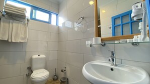 A bathroom with a toilet, sink, and a mirror. - Zehra Tatil Koyu (Fethiye)