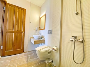 A bathroom with a wooden door, a sink, a toilet, and a shower. - Zehra Tatil Koyu (Fethiye)
