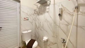 Kylpyhuone, jossa on wc, suihku ja pyyheteline.