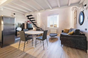 A modern living space with a dining area, a sofa, a staircase, and a view of the outside. - Giglio di Firenze (Florence)