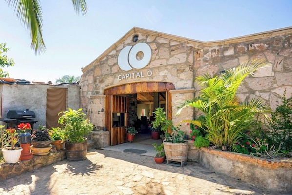 A stone building with a sign reading 'CAPITAL O' and a wooden entrance.