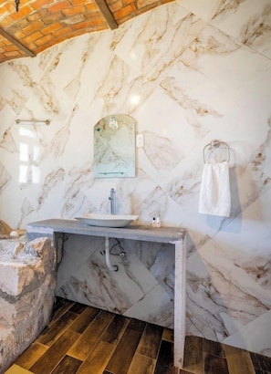 A bathroom with a marble wall, a sink, and a towel rack. - Collection O Hotel Monte Agave (Tequila)