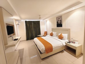 Una habitación de hotel con cama, mesita de noche, televisor y un cuadro en la pared.