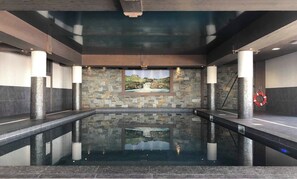 An indoor swimming pool with stone walls and a waterfall mural. - Les Arcs Apartment 1800 (73) —4 bedrooms, sleeps 10—at the foot of the slopes (Bourg-Saint-Maurice)