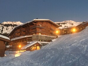 A multi-story lodge with balconies and a ski slope in the foreground. - Les Arcs Apartment 1800 (73) —4 bedrooms, sleeps 10—at the foot of the slopes (Bourg-Saint-Maurice)