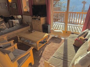 A cozy living room with a sofa, coffee table, and a television. - Les Arcs Apartment 1800 (73) —4 bedrooms, sleeps 10—at the foot of the slopes (Bourg-Saint-Maurice)