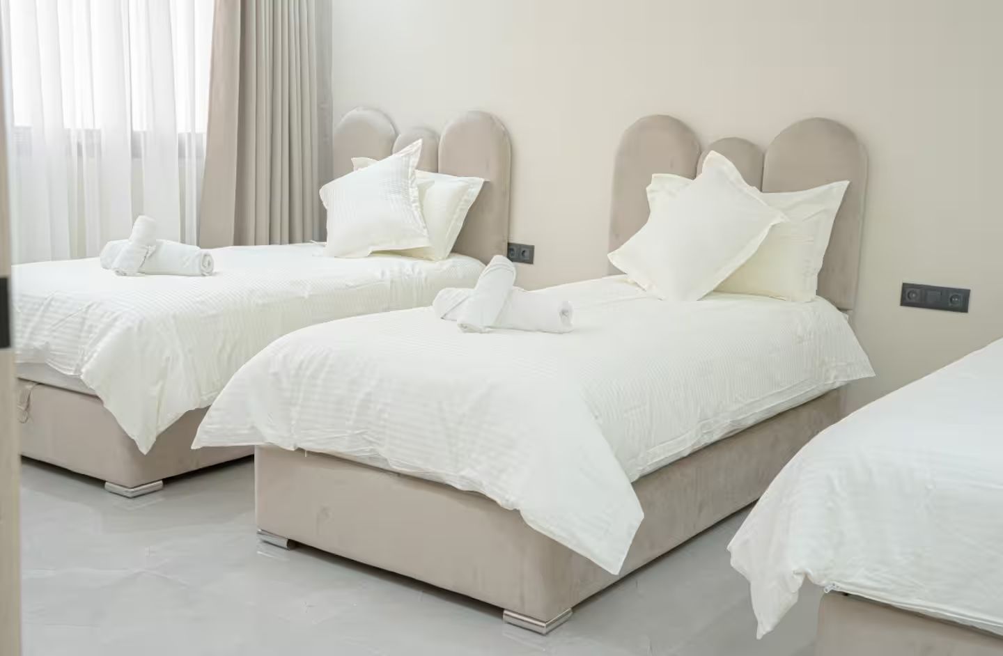 Une chambre d’hôtel avec deux lits, chacun doté d’une tête de lit et de linge de lit blanc.