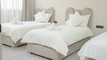 Une chambre d’hôtel avec deux lits, chacun doté d’une tête de lit et de linge de lit blanc.