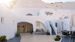 Un edificio blanco con una escalera que conduce a un espacio de descanso con cojines de colores.