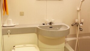 Ein kleines Badezimmer mit Toilette, Waschbecken und Badewanne.
