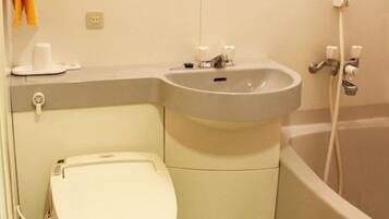A compact bathroom with a toilet, sink, and bathtub.