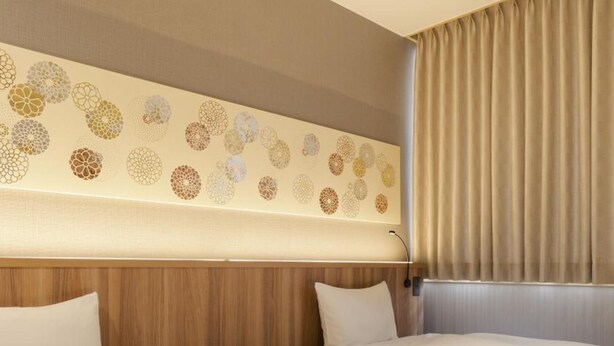 Ein Hotelzimmer mit zwei Betten, einem hölzernen Kopfteil und einer dekorativen Wandverkleidung.