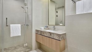 Ein modernes Badezimmer mit einer Duschkabine aus Glas, einem мраморному Waschbecken und einem Holzbadezimmermöbel.