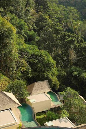 A resort with multiple buildings, a swimming pool, and lush greenery.