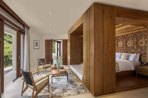 A modern bedroom with a large bed, wooden paneling, and a view of greenery outside.