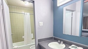 A bathroom with a shower, a sink, and a mirror. - Hotel Cartersville, GA (Cartersville)