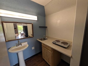 Una cocina compacta con pileta, encimera y estufa.